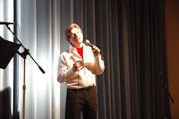 a man singing into a microphone on stage