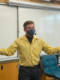 a man wearing a face mask in a classroom