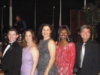 a group of people in formal attire posing for a photo