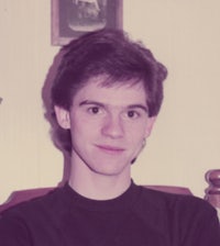 a young man in a black shirt sitting in a chair