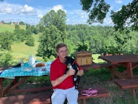 a man holding a dog on a picnic table